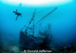 Silent Memory
Diver exploring the wreck of a small fishi... by Donald Jefferies 